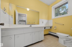 Expansive vanity with integrated sink, a large wall-mounted mirror, and white cabinetry - 