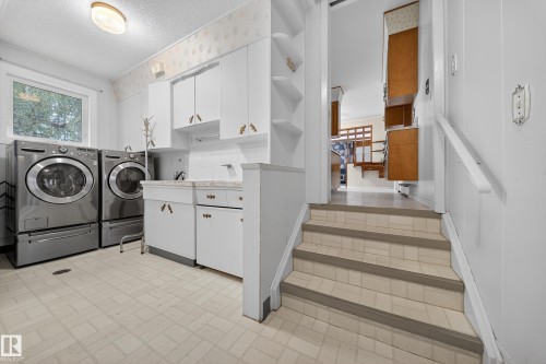 Dedicated laundry area featuring a window, built-in cabinetry, a utility sink, and wall shelving - 707 65 Avenue, Edmonton, AB 