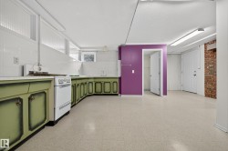 Spacious multi-purpose room featuring extensive green cabinetry, a white countertop, and white tile backsplash - 