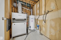 Utility area featuring a water heater, furnace, copper piping, and a water filtration system - 