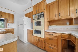 Kitchen featuring wood cabinetry, laminate countertops, a double wall oven, and tile flooring - 