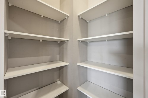 Corner pantry with multiple white built-in shelves - 7460 Singer Landing, Edmonton, AB 