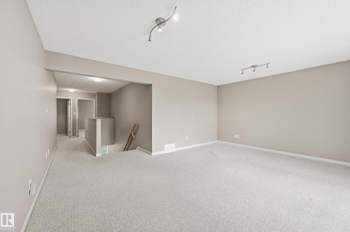 Spacious room featuring neutral carpeting and wall paint - 7460 Singer Landing, Edmonton, AB 