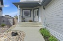 Inviting entryway featuring a white paneled door with glass inserts, concrete steps, and a complementary concrete walkway - 7460 Singer Landing, Edmonton, AB 