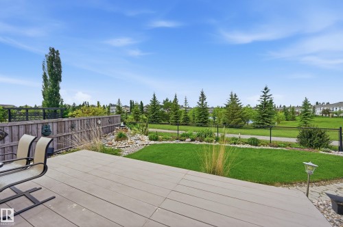 Spacious backyard featuring a composite deck, manicured lawn, and natural rock landscaping - 7460 Singer Landing, Edmonton, AB 