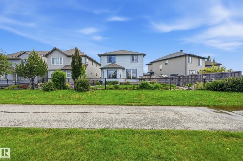 Rear exterior showcasing light blue siding and a bay window - 7460 Singer Landing, Edmonton, AB 