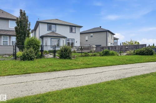 Rear exterior featuring light-colored siding and a dark roof - 7460 Singer Landing, Edmonton, AB 