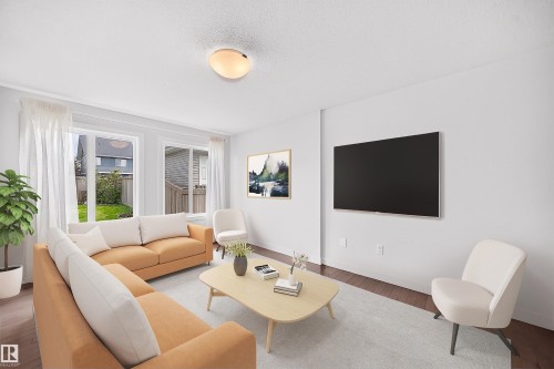 Bright living space featuring wood-finish flooring, white walls, and multiple windows - 2433 Glenridding Boulevard, Edmonton, AB 