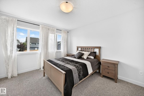 Bright room featuring a multi-pane window with white trim, a flush-mount ceiling light fixture, neutral-toned carpet flooring, and white painted walls - 2433 Glenridding Boulevard, Edmonton, AB 