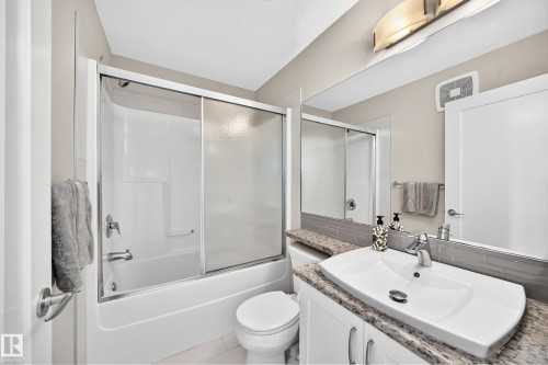 Bathroom featuring a white vanity with a granite-look countertop, an integrated vessel sink, and a chrome faucet - 2433 Glenridding Boulevard, Edmonton, AB 