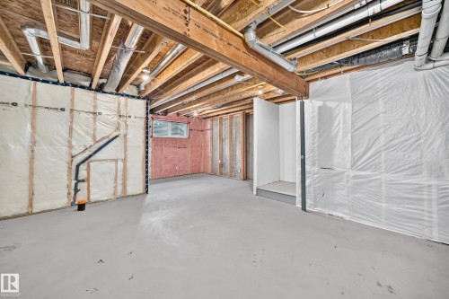 Unfinished basement space featuring exposed wood joists, concrete flooring, and partial wall insulation - 2433 Glenridding Boulevard, Edmonton, AB 
