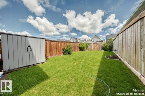 Expansive backyard featuring a manicured lawn, a brown wood privacy fence, and a gray storage shed - 2433 Glenridding Boulevard, Edmonton, AB 