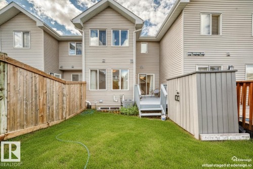 Fenced backyard featuring a manicured lawn, an elevated deck with steps, and a storage shed - 2433 Glenridding Boulevard, Edmonton, AB 