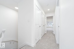 Hallway featuring recessed lighting, light gray carpeting, and multiple white panel doors - 