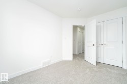 Neutral-toned wall-to-wall carpeting complements bright white walls and trim - 