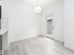 Bright interior space featuring light wood-finish flooring and white walls - 