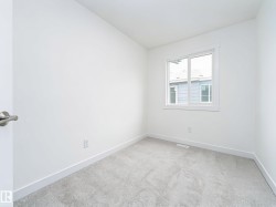 Bright room featuring neutral carpeting, white walls, and a window with white trim - 