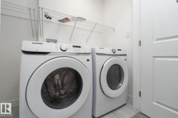 Dedicated laundry area featuring front-loading appliances, white cabinetry, and overhead wire shelving - 