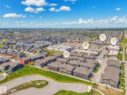 Aerial perspective showcasing a residential community with multi-story townhomes and single-family residences - 