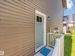 Entryway with a light green paneled door featuring a window insert and white trim - 