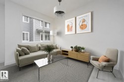 Bright living space featuring white walls and light-toned wood-finish flooring - 