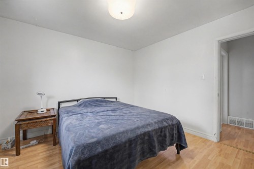 Bedroom featuring light wood-finish flooring and white painted walls - 12707 87 Street, Edmonton, AB 