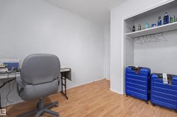 Room featuring wood-finish flooring, white painted walls, and a built-in closet - 