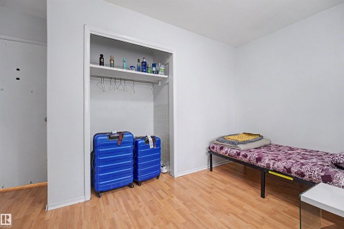 Room featuring light wood-finish flooring and a built-in closet with shelving and a hanging rod - 12707 87 Street, Edmonton, AB 