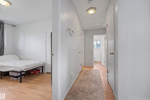 Light-colored wood-finish flooring extends throughout the hallway and into a partial room - 12707 87 Street, Edmonton, AB 