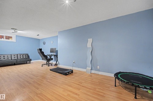Spacious room featuring wood-finish flooring and light blue walls - 12707 87 Street, Edmonton, AB 