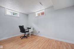 Bright room featuring wood-finish flooring, light grey walls, white baseboards, and two transom windows - 
