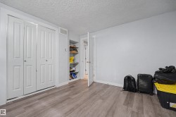 Room featuring wood-finish flooring, light grey walls, and white trim - 