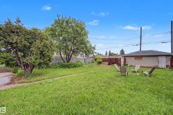 Expansive grassy yard with mature trees and perimeter fencing - 
