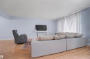 Bright living area with wood-finish flooring, light blue walls, and white baseboards - 12707 87 Street, Edmonton, AB 
