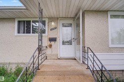 Front entry with concrete stairs and black metal railings - 