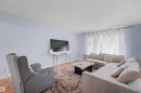 Living area featuring light wood-finish flooring and a patterned area rug - 12707 87 Street, Edmonton, AB 