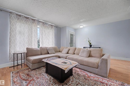 Living area featuring wood-finish flooring and light blue walls - 12707 87 Street, Edmonton, AB 