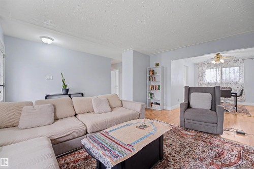 Spacious room featuring light-toned walls, wood-finish flooring, and a defined entry to an additional area - 12707 87 Street, Edmonton, AB 