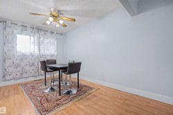 Bright interior space featuring wood-finish flooring, light blue walls, and a ceiling fan with integrated lighting - 