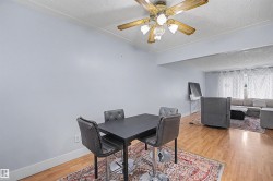 Open concept living area with wood-finish flooring and a ceiling fan - 