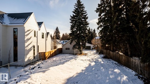 Expansive cleared lot featuring partial wood fencing and mature evergreen trees - 14307 Summit Drive, Edmonton, AB 