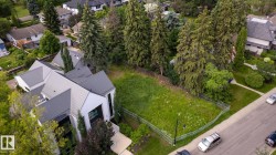 Expansive undeveloped lot featuring mature perimeter trees and a verdant grassy surface - 