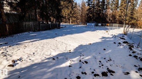 Expansive lot featuring mature trees along the perimeter and a partial wooden fence - 14307 Summit Drive, Edmonton, AB 