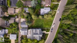 Aerial perspective showcasing a residential neighborhood with varied property sizes and tree coverage - 