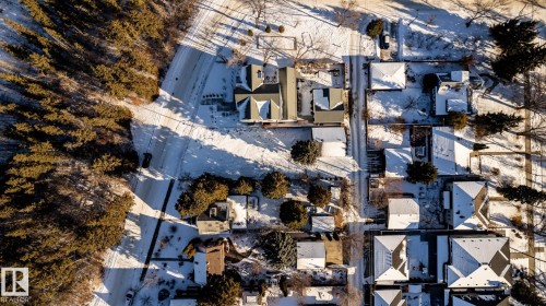 Aerial view showcasing a residential area bordered by dense evergreen trees - 14307 Summit Drive, Edmonton, AB 
