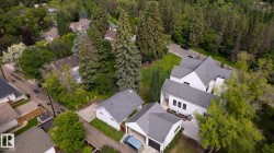 Contemporary residence featuring white exterior siding, a multi-gabled metal roof, and dark-framed windows - 