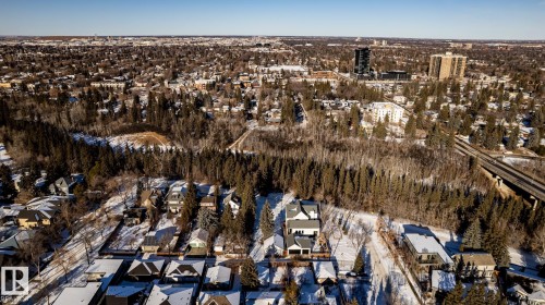 Expansive aerial perspective showcasing a residential area bordered by mature forest - 14307 Summit Drive, Edmonton, AB 