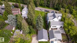 Contemporary residence featuring a white exterior, gray metal roofing, multiple rooflines, a private rear patio, and an attached garage with a gray metal roof - 