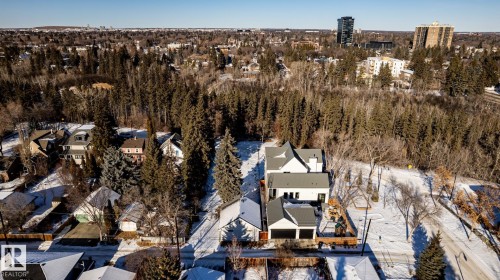 Modern white residence featuring a dark gray roof, prominent gables, and an attached two-car garage - 14307 Summit Drive, Edmonton, AB 