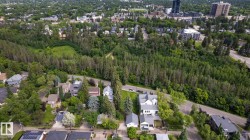 Aerial perspective showcasing a verdant landscape with extensive tree cover, residential streets, and distant urban structures - 